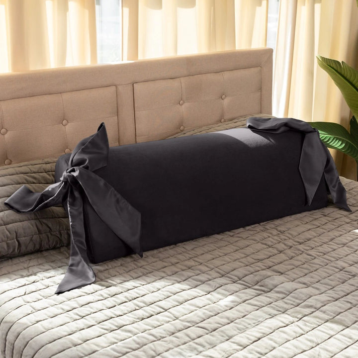 Liberator Ravish Bondage Pillow in Schwarz mit Satin-Bändern, elegant auf Bett drapiert – diskretes Liebesspiel-Accessoire